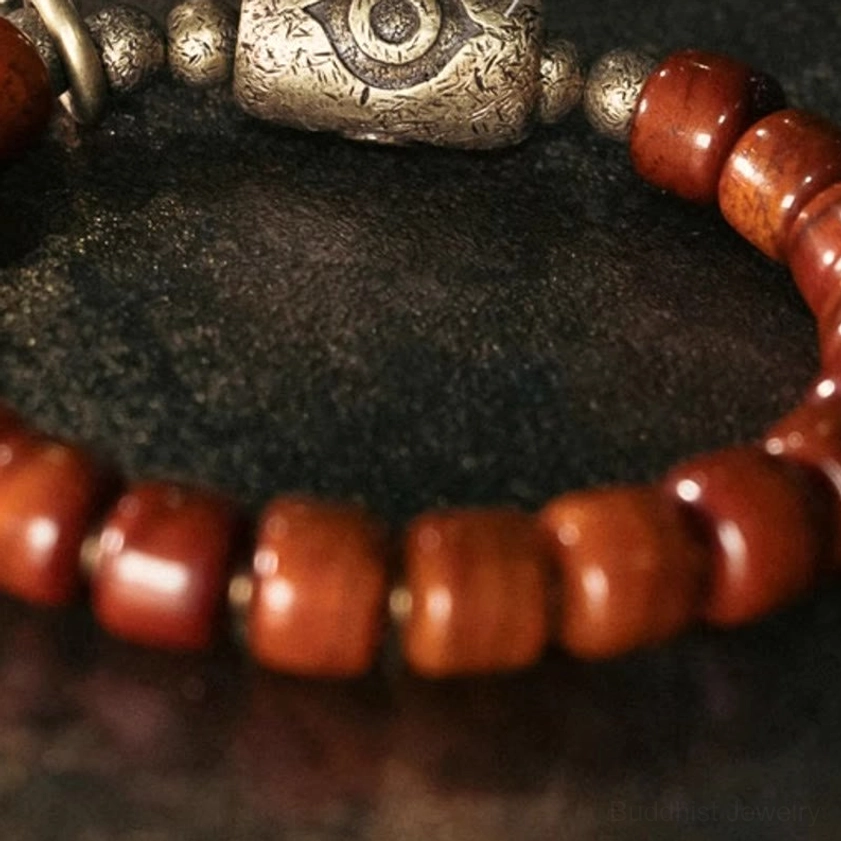 Ultra-close-up extreme macro of Dzi eye bead showing carved details smooth wooden beads and antique bronze finish