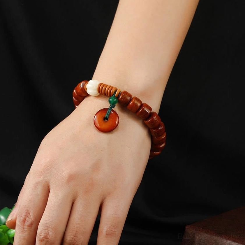 Lotus peace buckle bone bead bracelet worn on wrist close-up detail shot