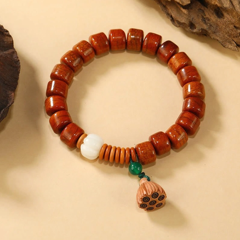 Bone beads bracelet with wooden lotus pod charm flat lay overhead shot