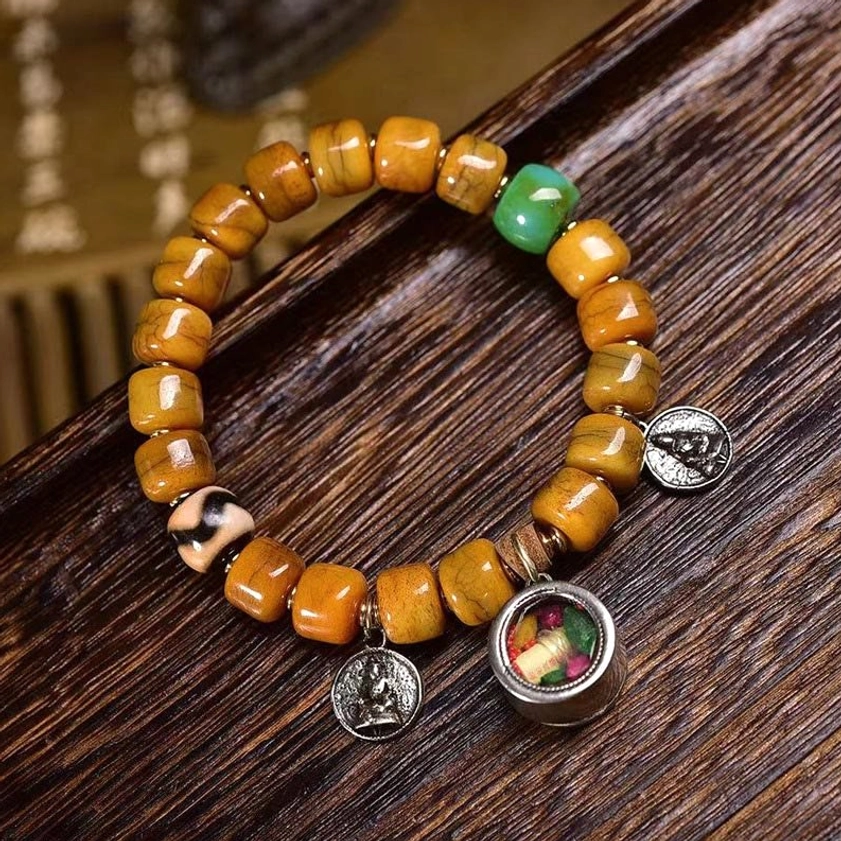 Handcrafted bone bead bracelet with dzi stone, dual metal pendants, and fox charm detail