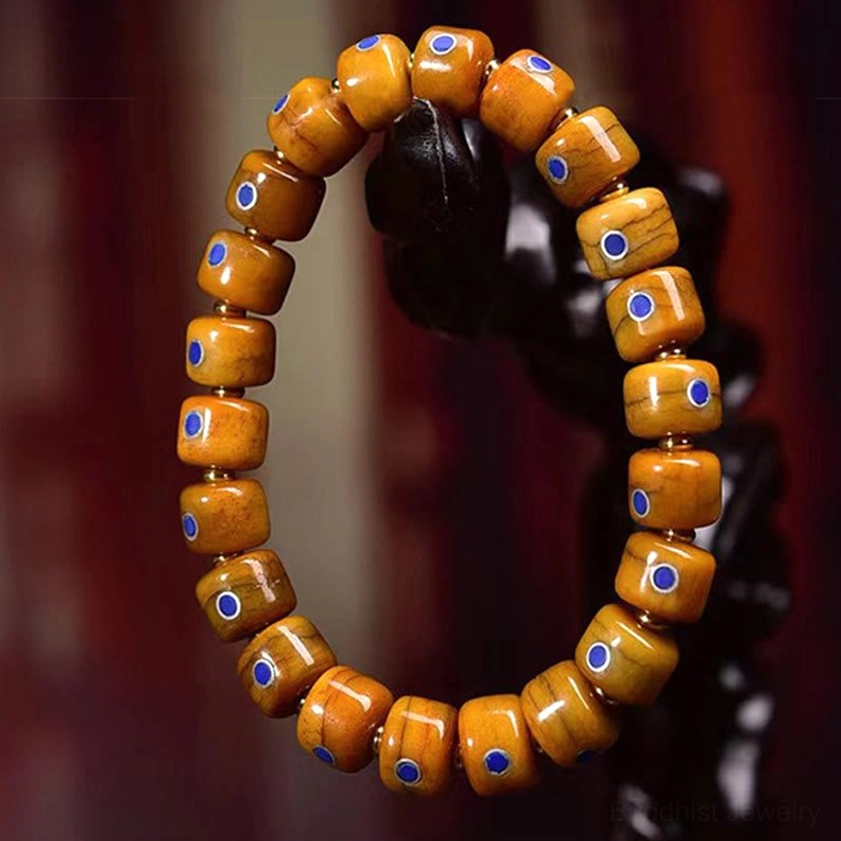 Orange bone bead mala bracelet hanging on black background without pendants showing simple design
