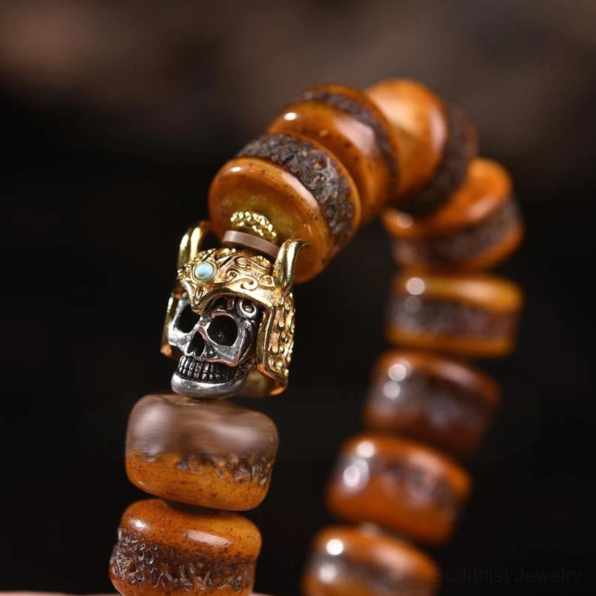 Close-up detail of bone skull bracelet with intricate metal skull charm featuring turquoise accent – low angle macro shot