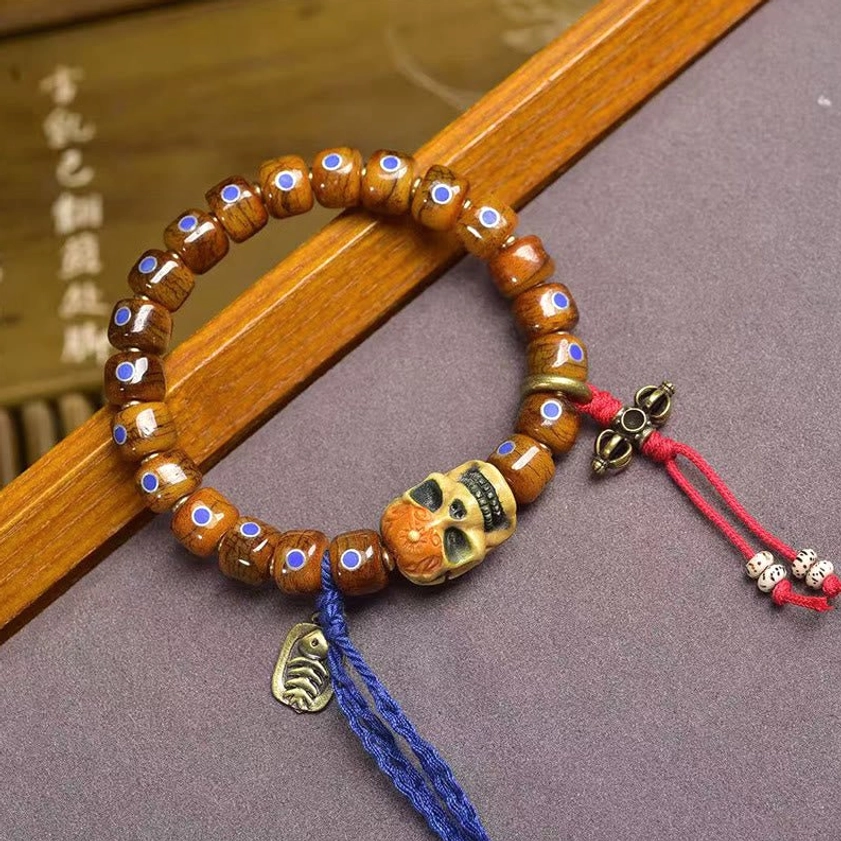Handcrafted bone skull bracelet with inlay details and decorative tassels for Buddhist meditation and spiritual protection