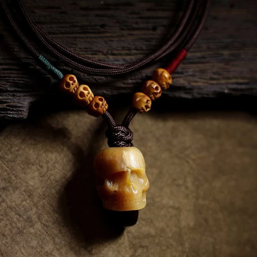 Full bone skull pendant displayed in palm of hand showing complete size and design