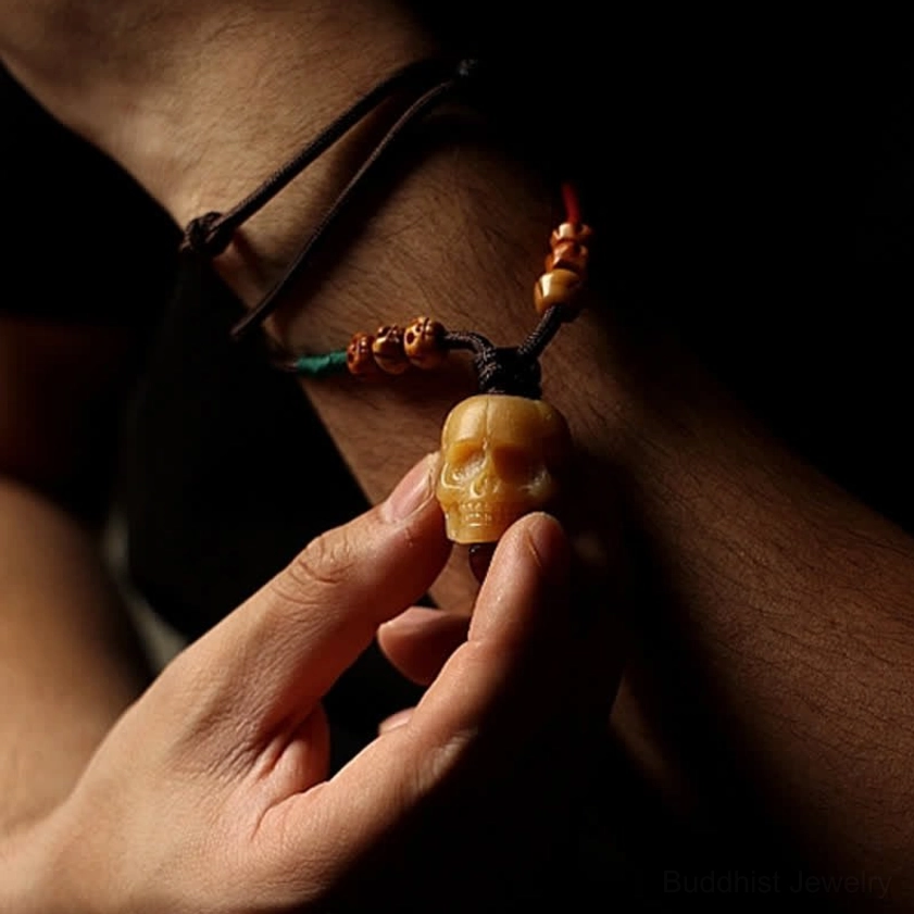 Bone skull pendant necklace displayed on wrist showing versatile wear options