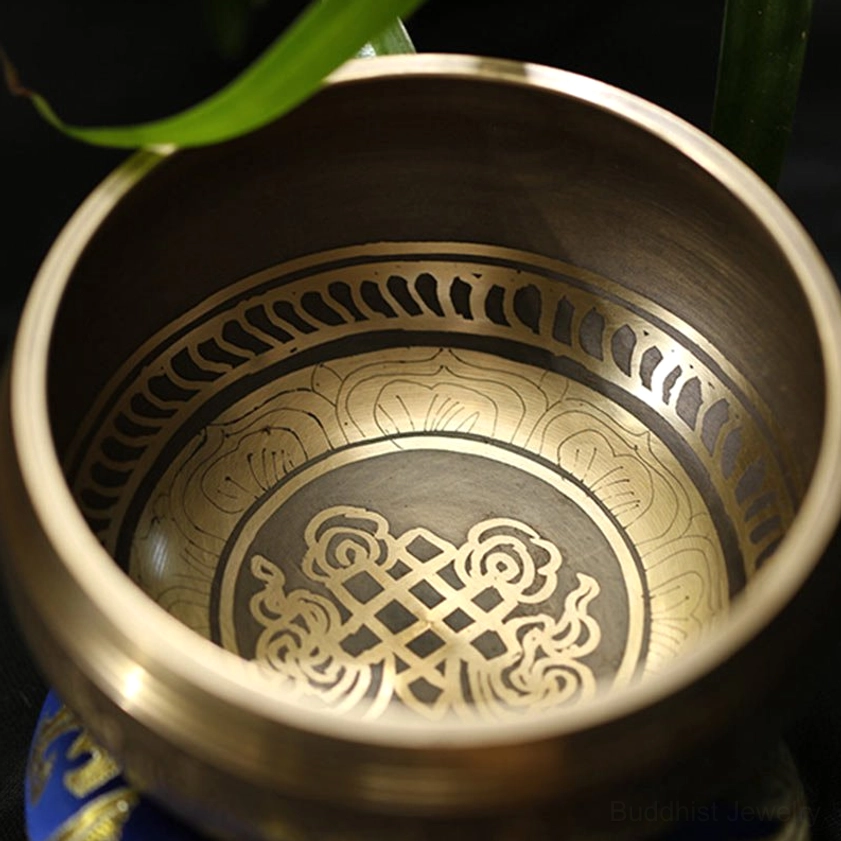 Detailed close-up of intricate floral engravings and glossy bronze finish inside Buddhist meditation bowl