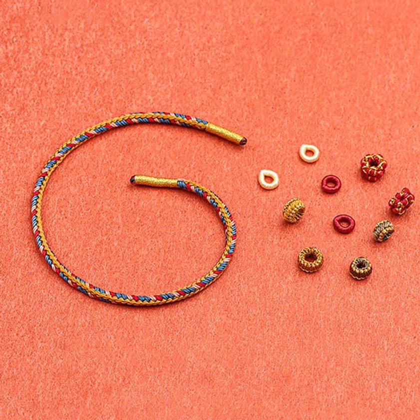Dunhuang bracelet making components artisan craftsmanship braided cords and decorative knot beads on display