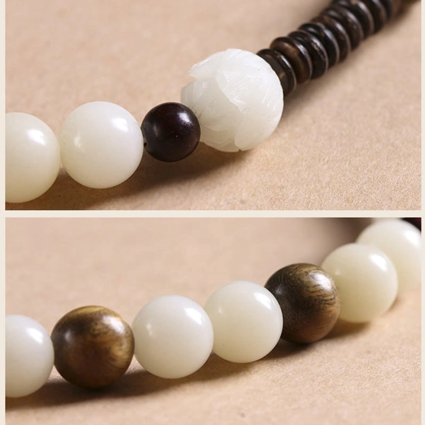 Buddhist double wrap meditation bracelet materials close-up showing bodhi seeds, sandalwood beads, jade, and peace buckle construction