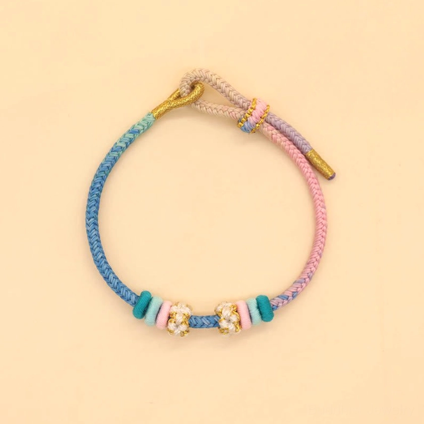 Eight-thread braided luck bracelet in blue, pink, and light purple with peach blossom ornament
