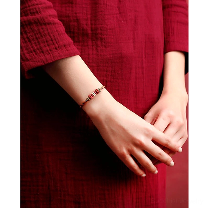 Buddhist string bracelet side wrist wear view slim multicolor design red gold decorative details