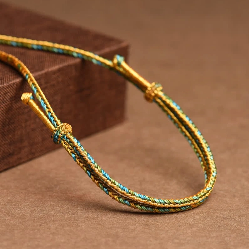 Gold and green braided copper Buddhist necklace strap detail showing adjustable gold metal clasp and closure mechanism