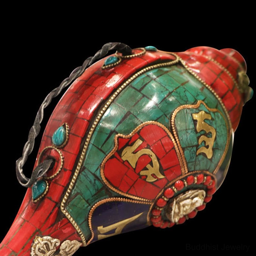 Side angle detail of braided hanging cord and turquoise gemstone decoration on Buddhist Shankha ornament