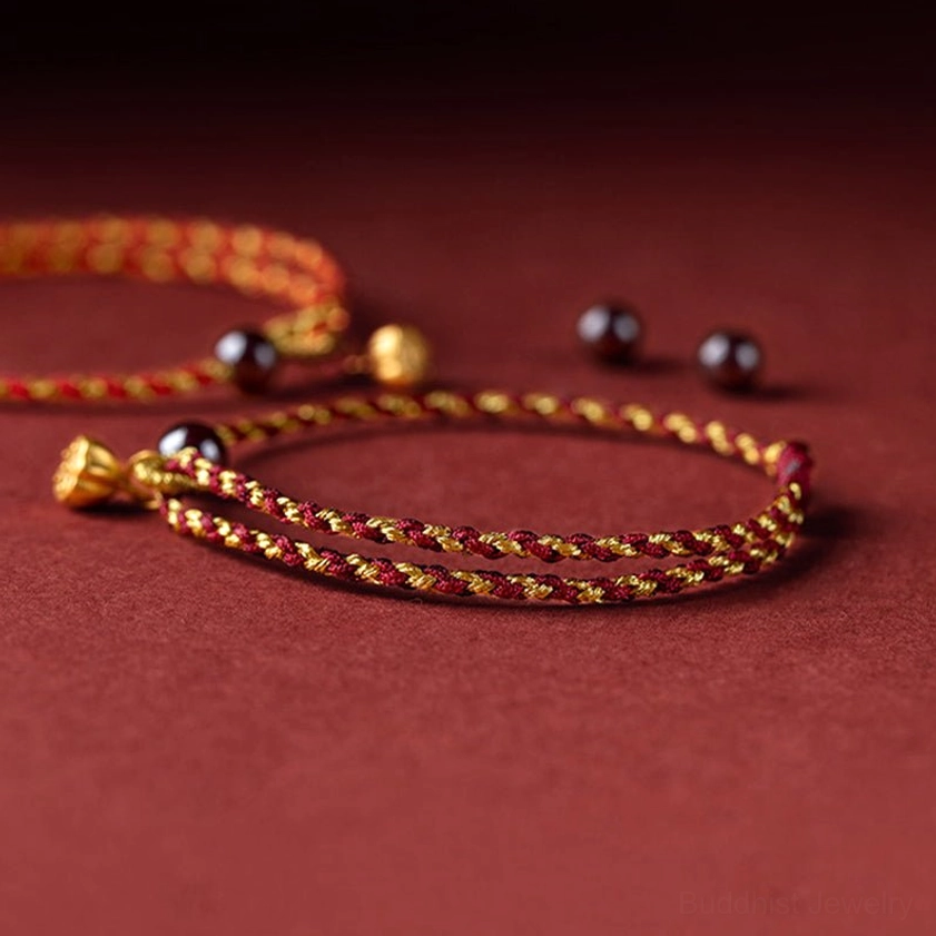 Red gold twisted rope bracelet with scattered dark purple meditation beads and metal accents