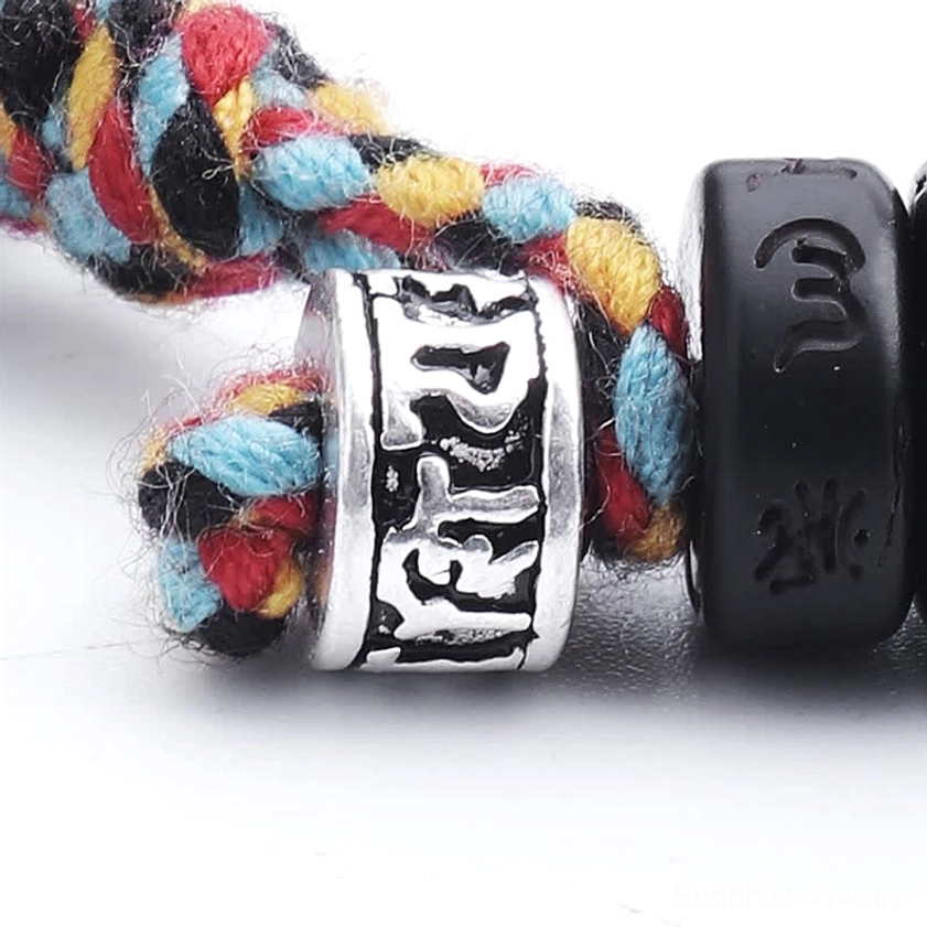 Detail of multicolor braided tassel closure and silver engraved charm bead on Buddhist mantra bracelet