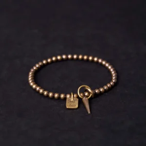 Vintage brass beaded bracelet with Good Luck charm and cone pendant - overhead view showing Buddhist fortune bracelet design