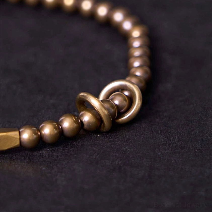 Close-up side view of polished bronze tone brass couple bracelet showing metal toggle clasp and bead texture