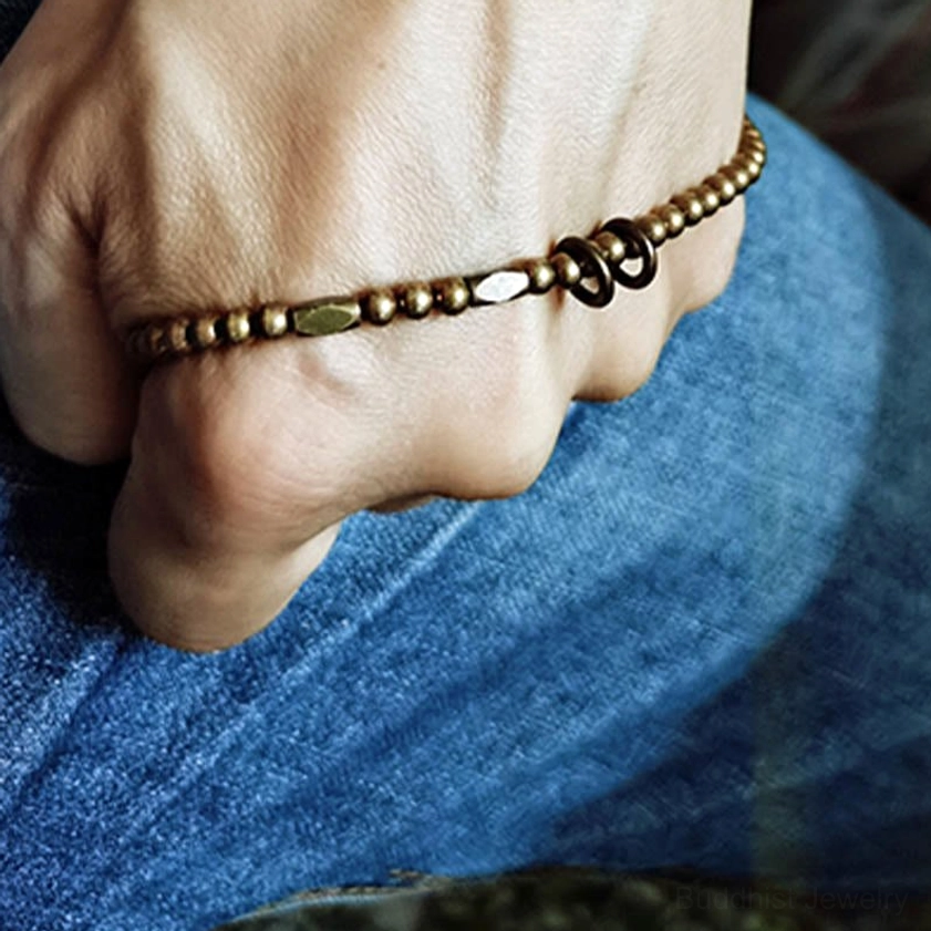 Men's bracelet lifestyle close-up wrapped around hand knuckles on denim jeans showing secure toggle clasp