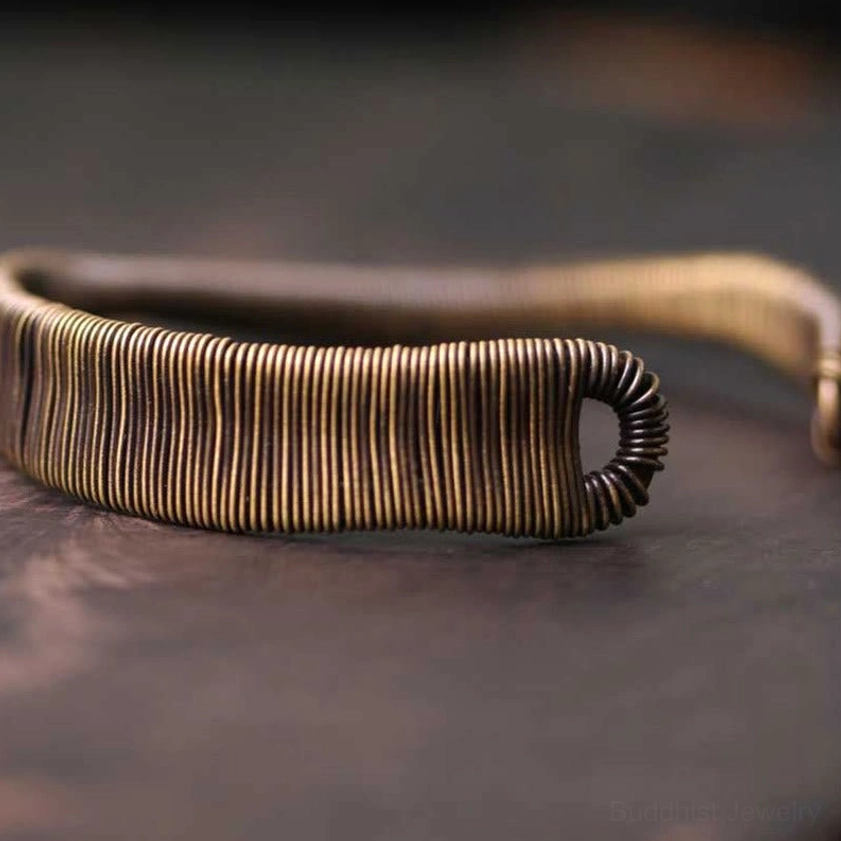 Brass cuff bracelet flat side view displaying hook-style open ends and adjustable oval opening design