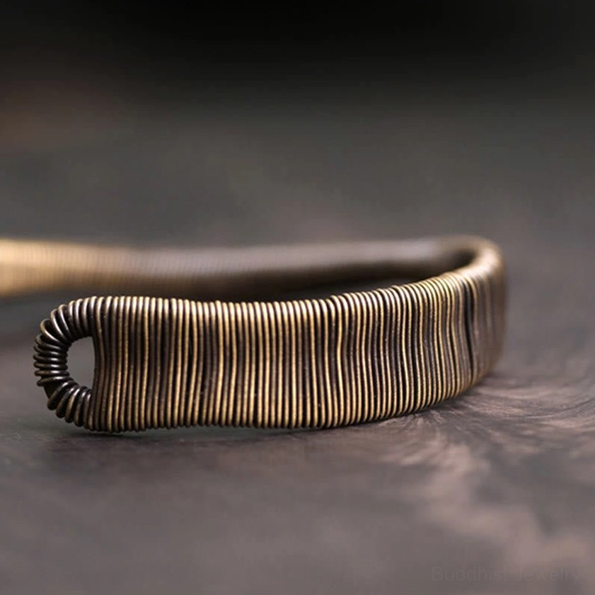 Brass cuff bracelet side flat view featuring flat wrapped wire face and oval hook opening detail