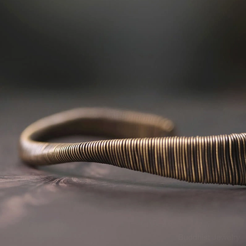 Twisted wire brass cuff bracelet flat side view with curved wrapped band texture and modern minimalist design
