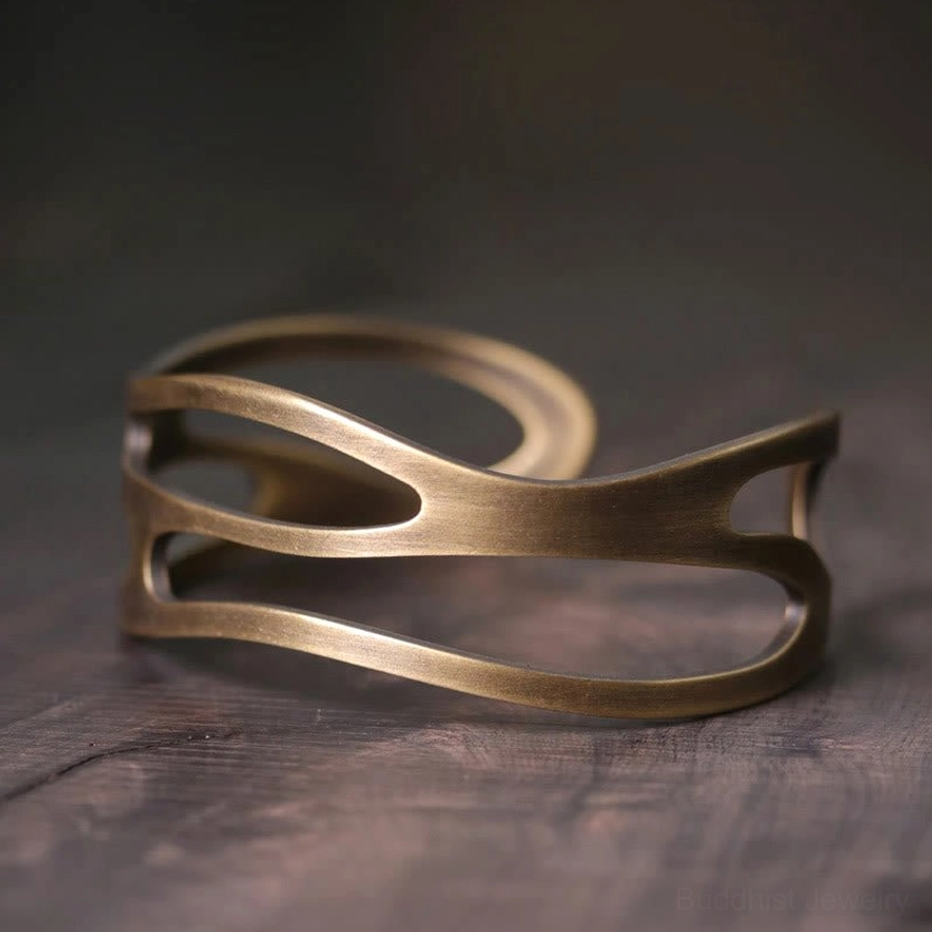 Double-layer brass cuff bracelet side three-quarter view highlighting streamline hollow cutout structure and vintage bronze tone