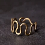 Adjustable curved brass wave ring front close-up view showing intricate wavy design and antique bronze finish