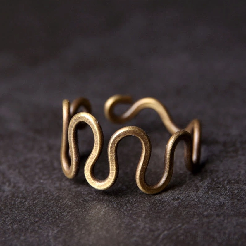 Adjustable curved brass wave ring front close-up view showing intricate wavy design and antique bronze finish