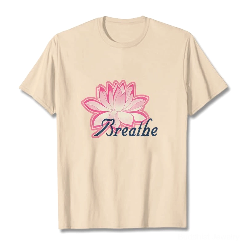Breathe lotus flower beige light tan t-shirt flat lay with pink lotus graphic and dark blue text on neutral background