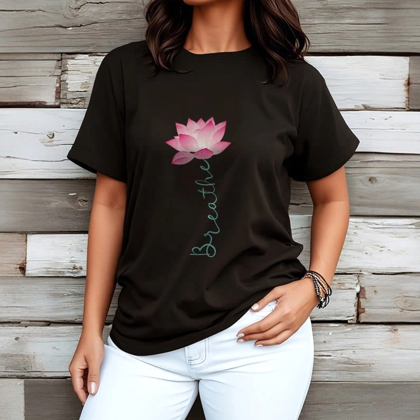 Woman wearing black breathe lotus mindfulness shirt with white jeans wooden wall background