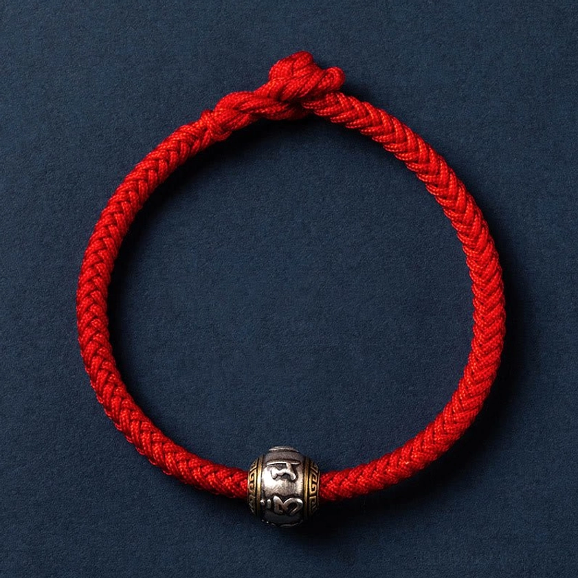Bright red Buddhist string bracelet with silver decorative bead, colorful accent threads, and adjustable knot closure for protection