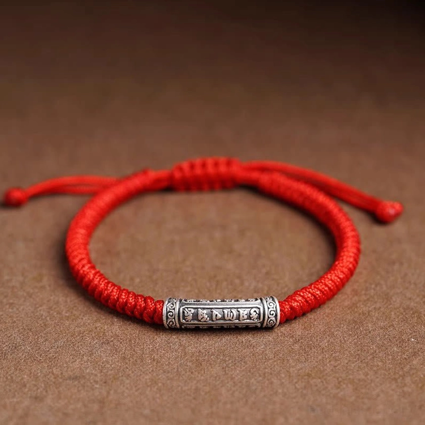 Bright red Om Mani Padme Hum string bracelet with adjustable cord and silver pendant