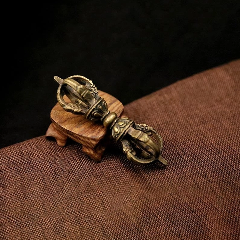 Single bronze five-prong vajra dorje close-up showing ornate hand-carved details and dark antique bronze tone