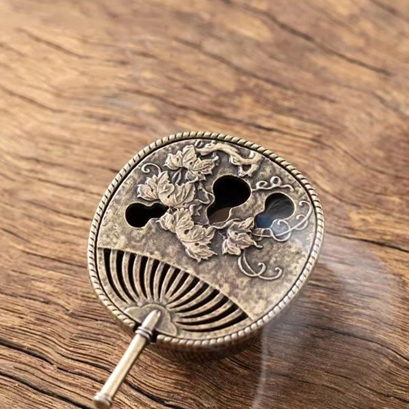 Bronze pipa-shaped incense holder with carved gourd motifs and fan vents releasing aromatic smoke