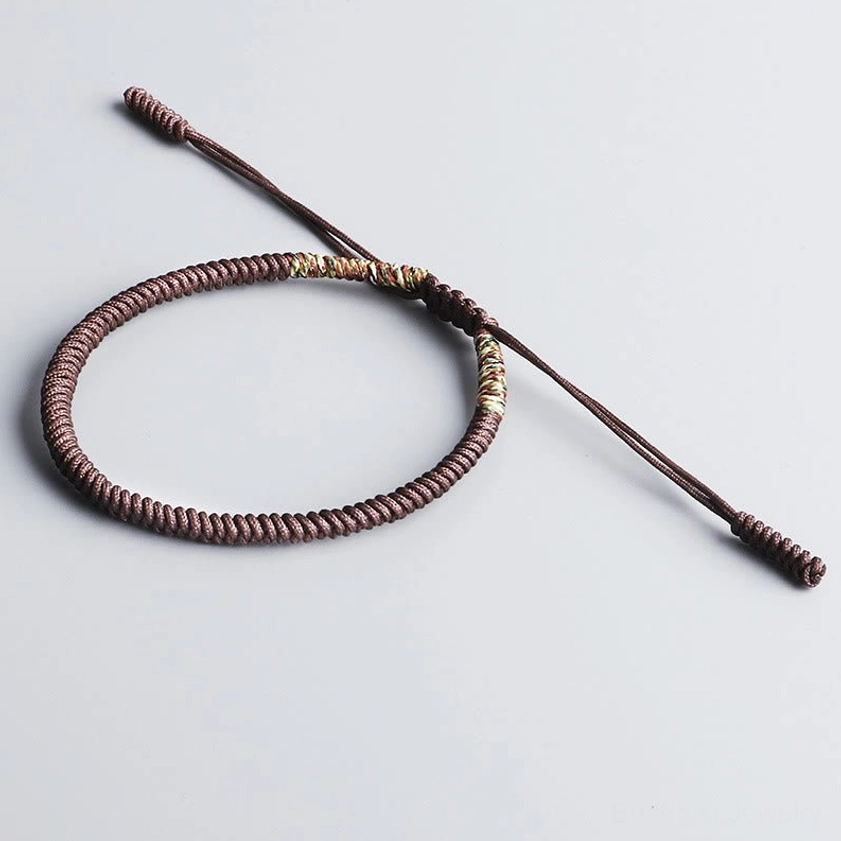 Single handmade Buddhist bracelet in brown with King Kong Knot amulet, showing tight woven cotton cord construction