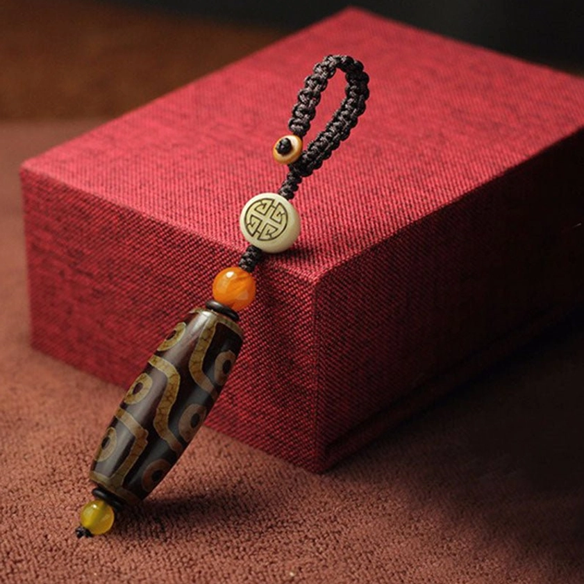 Brown agate dzi bead keychain with round pattern charm and mixed color spacer beads on gift presentation for wealth and protection