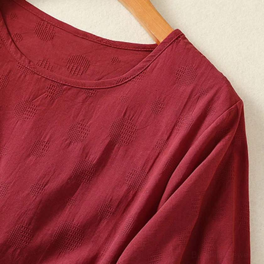 Curved hem detail of brown meditation yoga top - showing asymmetric design and fabric weave
