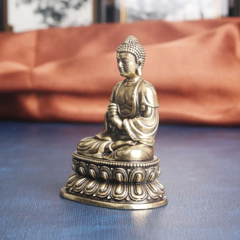 Right side profile of brass Buddha meditation statue, ritual hand position and carved robe textures visible