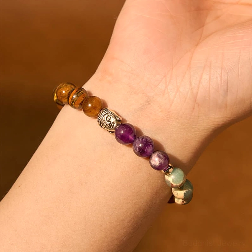 Handcrafted gemstone bracelet being worn on female wrist with brown background