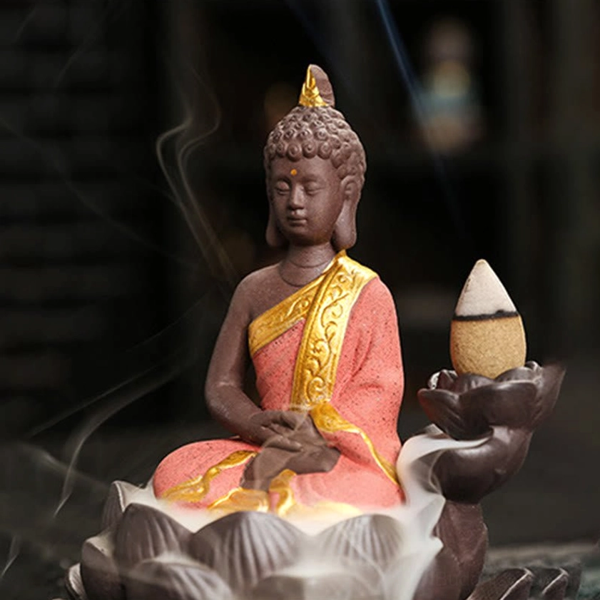 Buddha backflow incense burner left side view showing red ceramic robe with visible cascading smoke waterfall effect