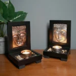 Bronze Buddha tealight candle holder front view with lit candle on wooden tabletop - meditation altar decor
