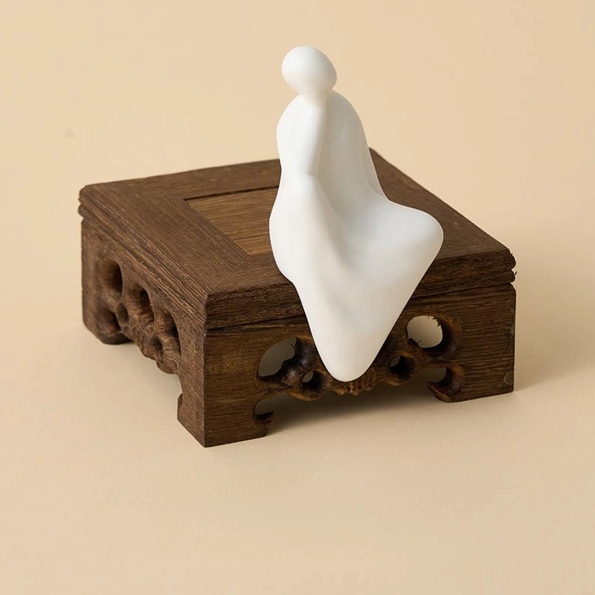 Zen meditation Buddha ceramic figure with dark brown carved wenge wood stand, right three-quarter professional studio view