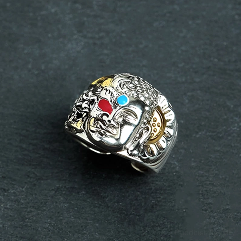 Half demon half Buddha copper ring low-angle side view with dark background, showing carved ear details and mixed metal tones with turquoise and red accents