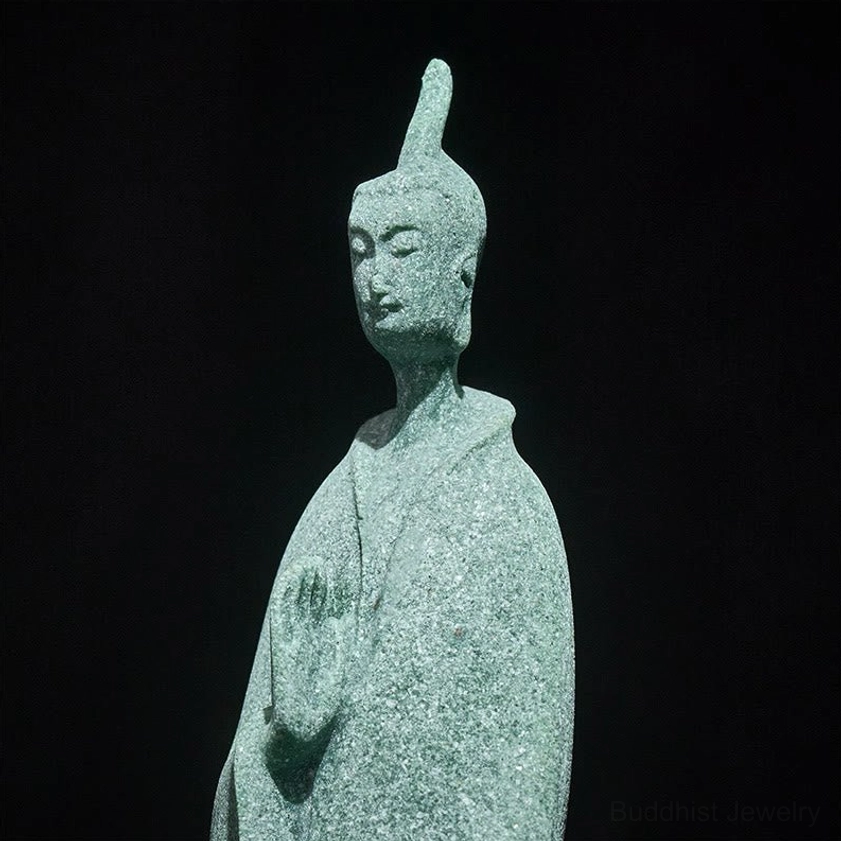 Close-up of standing Buddha statue face and upper body showing serene expression and coarse stone texture