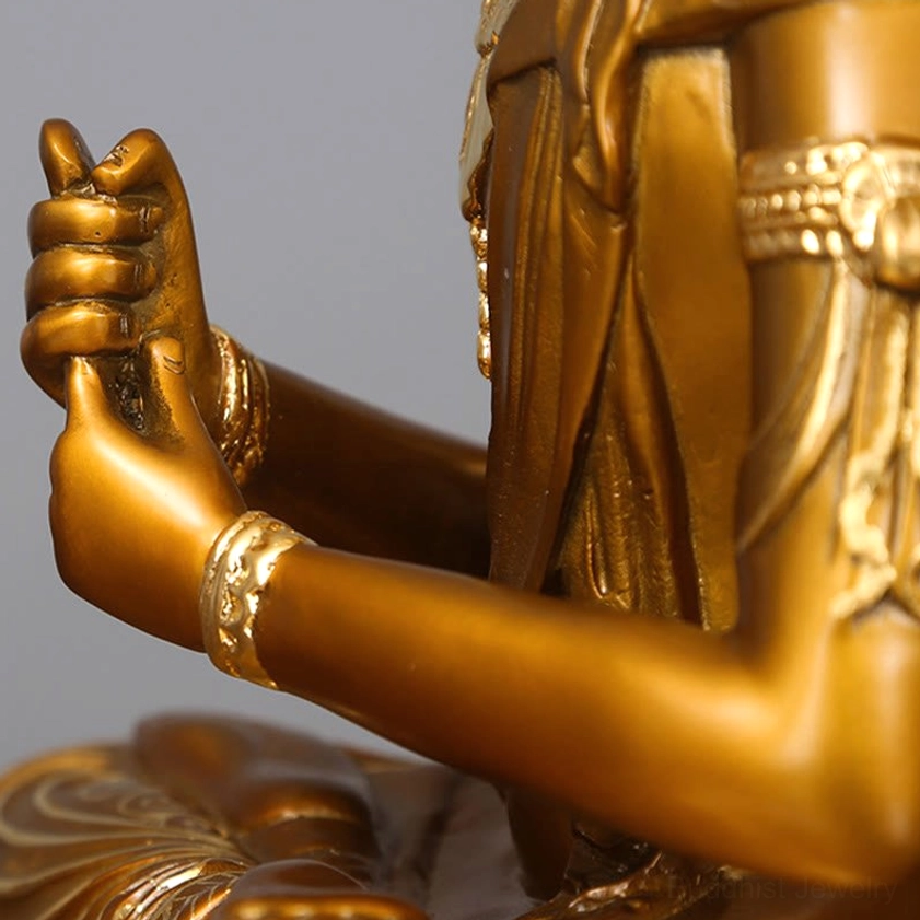 Extreme close-up of handcrafted Buddha statue hands showing detailed prayer mudra and ornate wrist bands