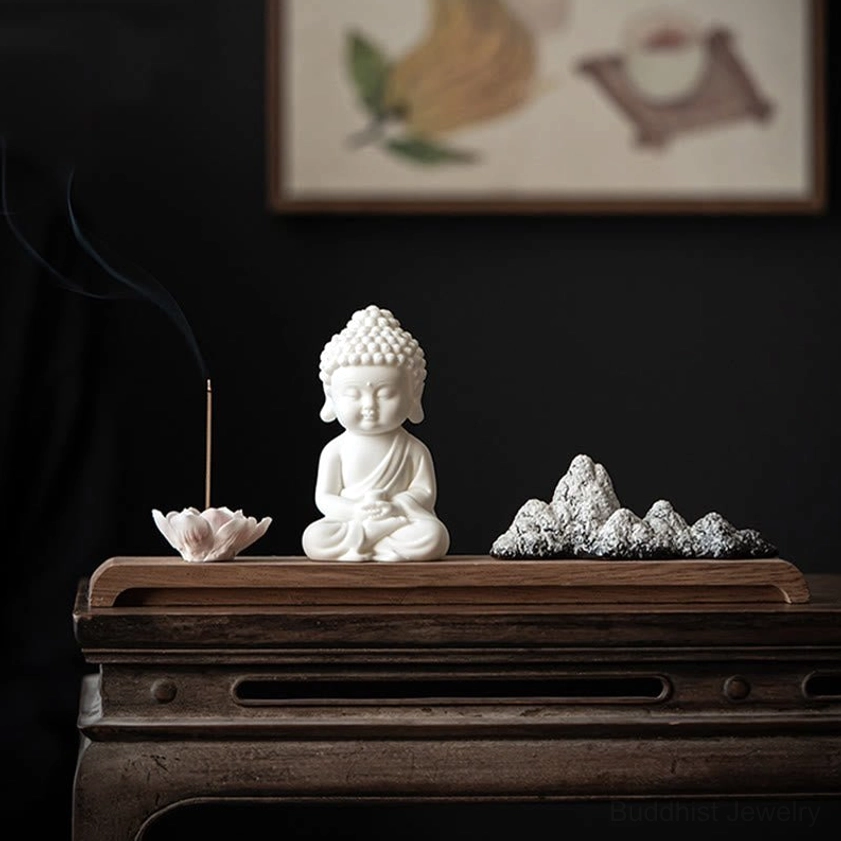 Buddha meditation figurine incense burner displayed on vintage wooden cabinet with Asian wall art