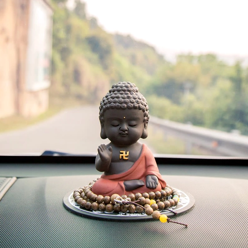 Rear close-up of handcrafted Buddha statue showing curved back and intricately detailed curly hair texture on natural purple clay
