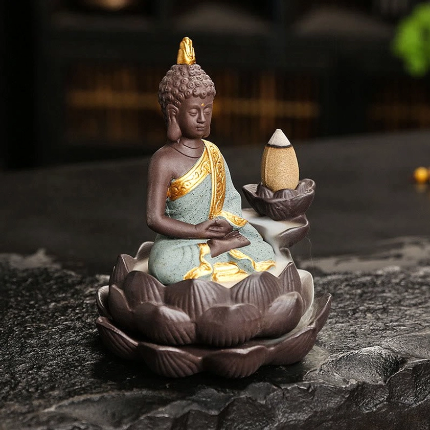 Golden Buddha incense burner with meditation mudra and ornate hand-painted ceramic robe on dark surface