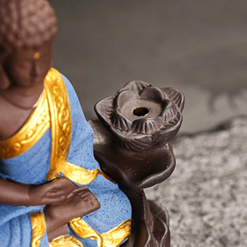 Green ceramic Buddha burner with prayer blessing hands in gratitude pose on dark surface