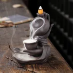 Buddha hand backflow incense burner ceramic teapot with brown-black finish showing cascading smoke effect