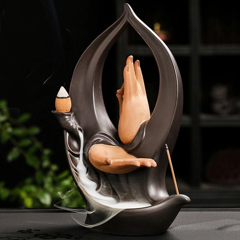 Buddha Hand backflow incense burner three-quarter view showing teaching mudra hands with flowing smoke cascade and open leaf frame design